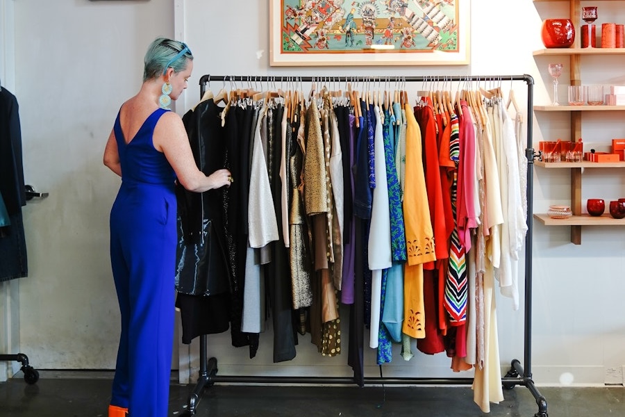A stylish shopper browses a rack of colorful vintage clothing at a boutique in Washington, DC.