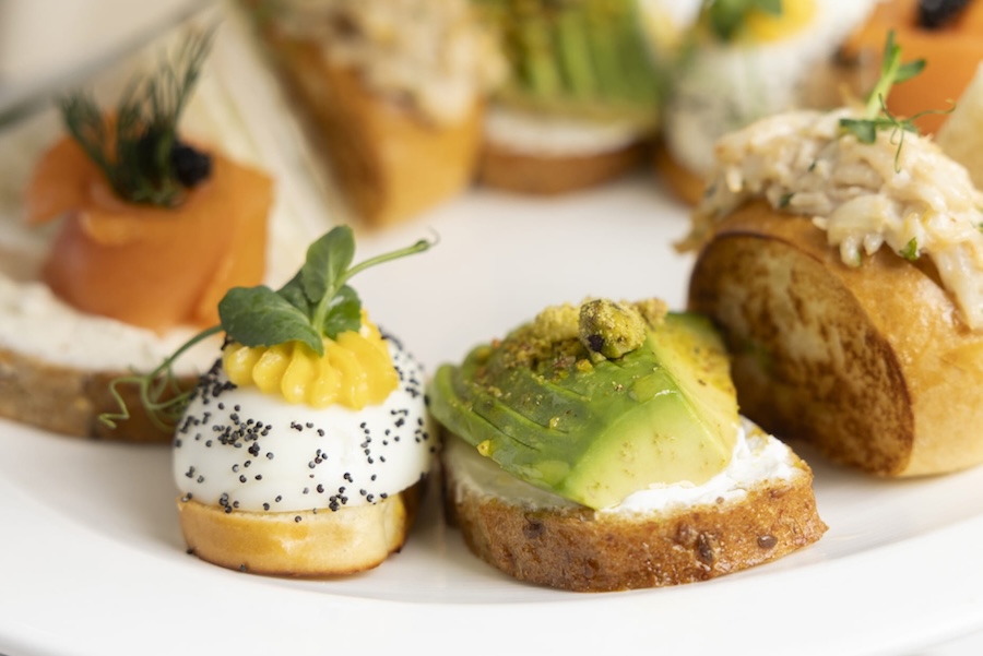 A plate of intricately prepared toasts with delicate toppings. 