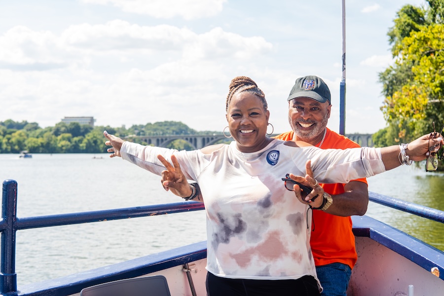A couple smiles and mimics the Titanic pose on a boat tour along the Potomac. 