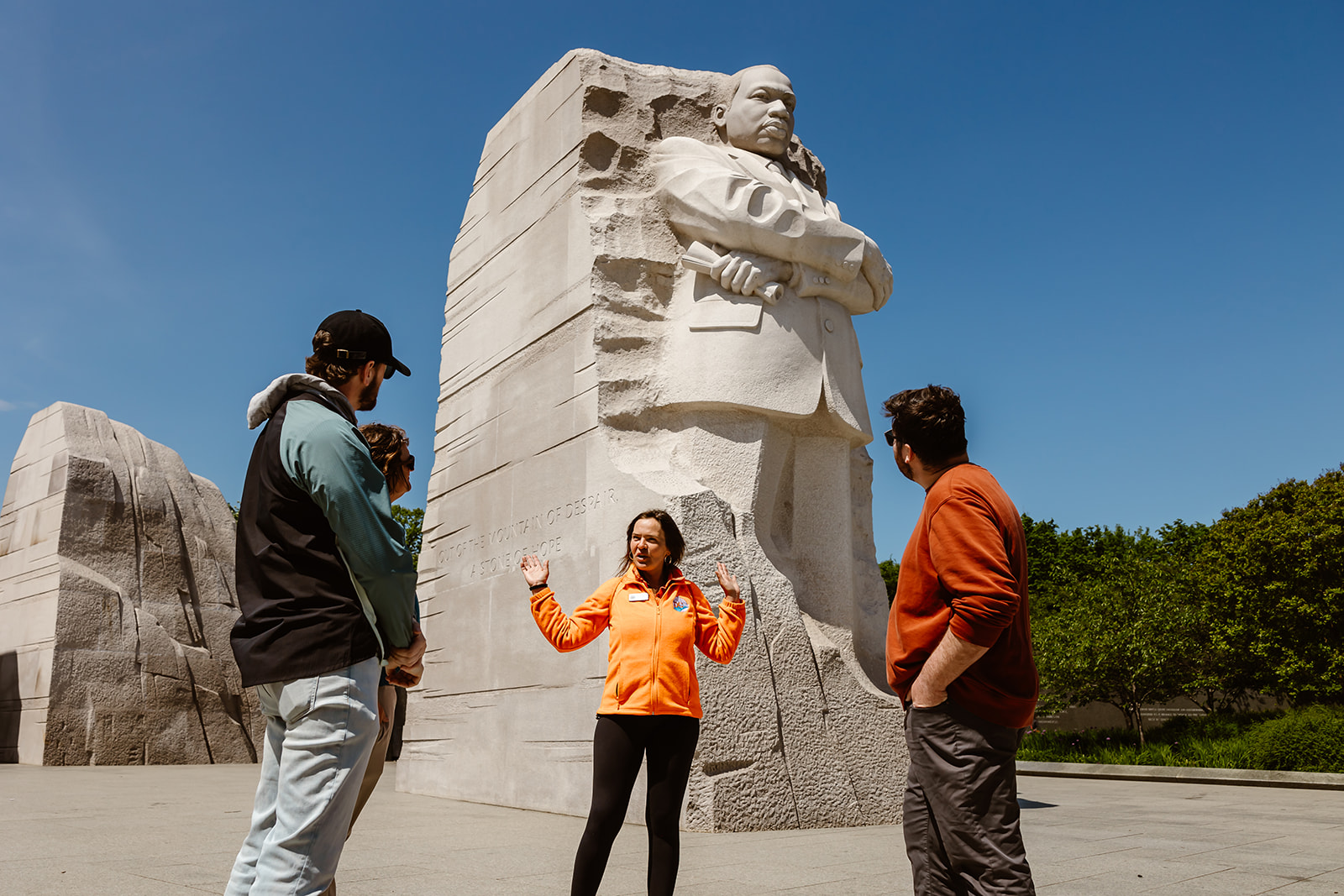 A tour guide speaks in front of the MLK Memorial in DC. 