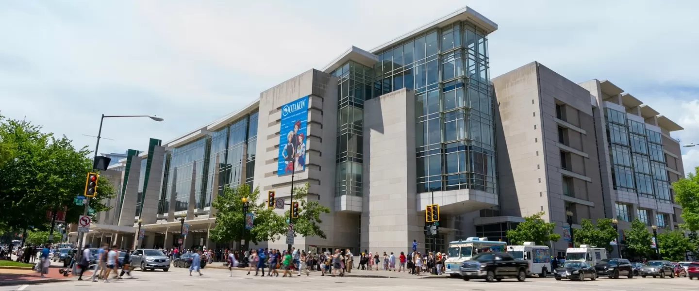 The exterior of the Walter E. Washington Convention Center on a bright day with crowds walking along the street.