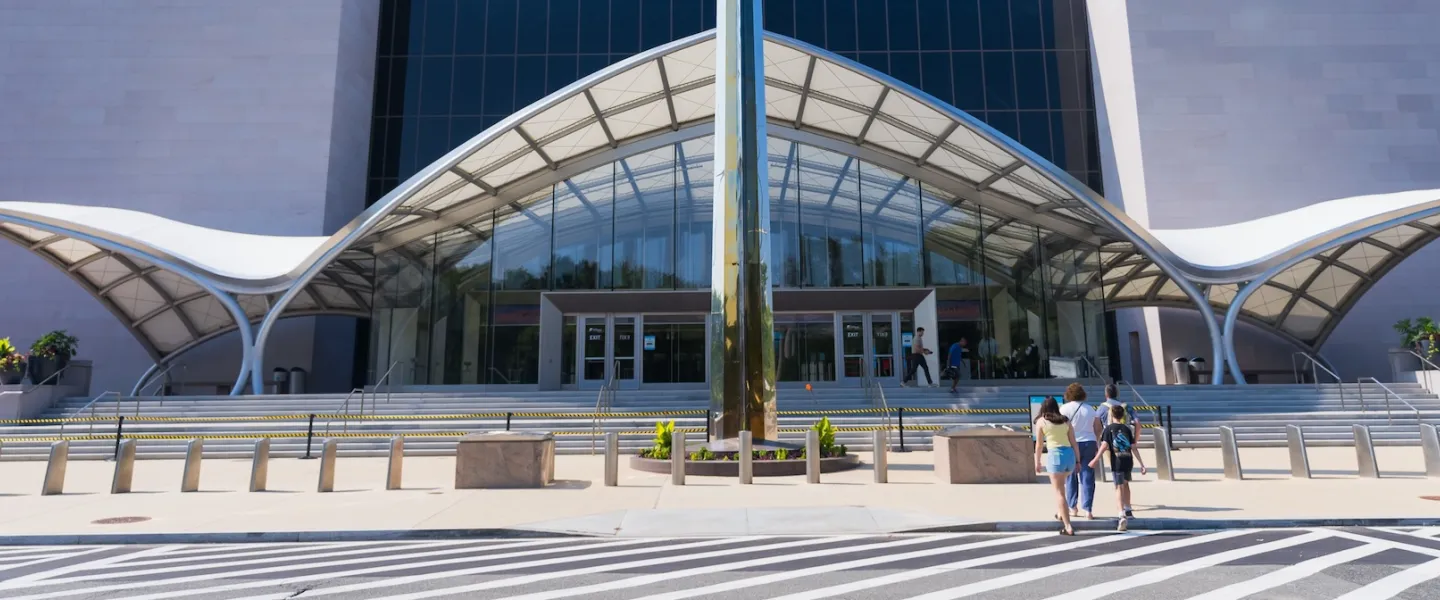 Visitors approach the dramatic glass-and-metal entrance of the National Air and Space Museum.