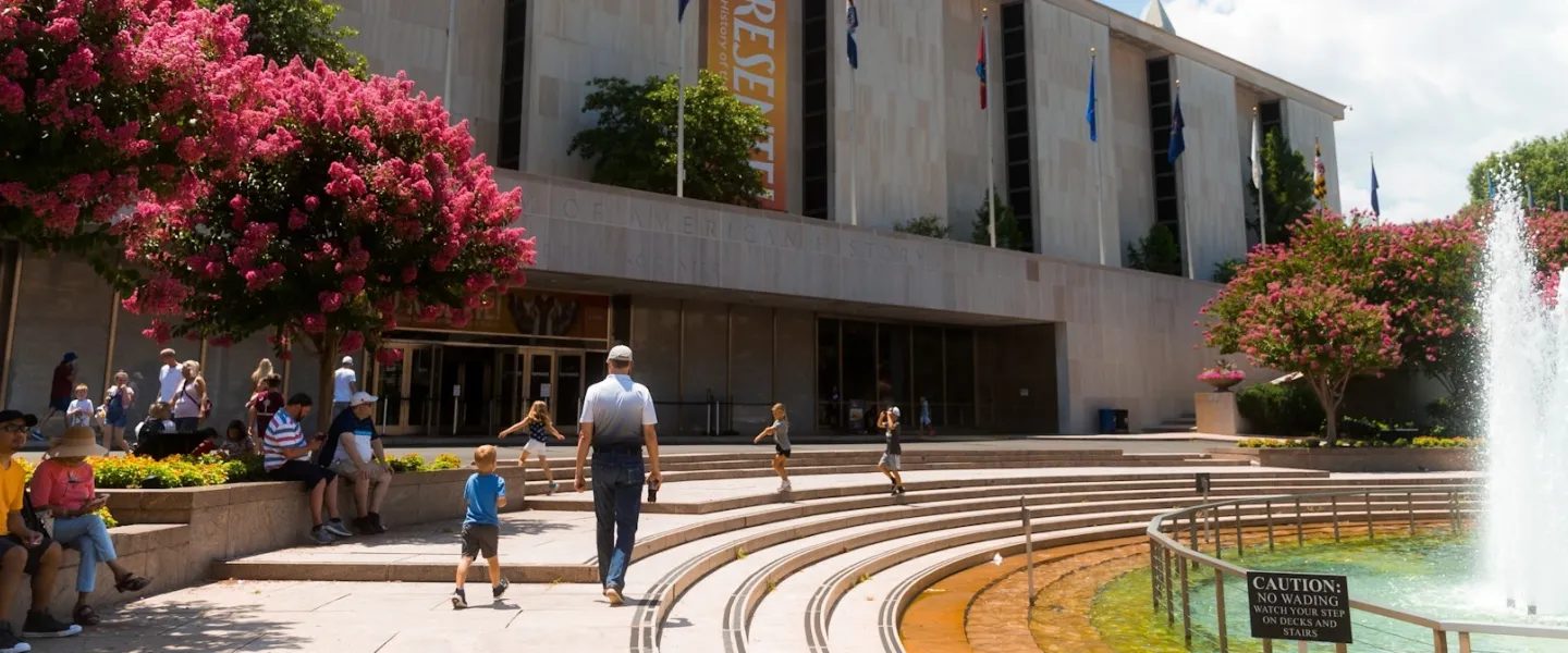 People gather near the fountain outside the National Museum of American History.