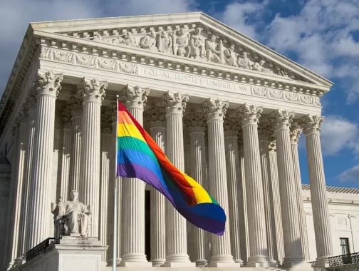 An LGBTQ+ flag flies in front of the Supreme Court. 